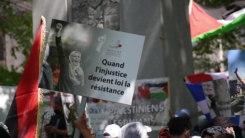 Montreal, QC, Canada - May 16 2021: Protesters with Palestinian flag, scarf signs against Israel bombing innocent civilian casualties in Gaza. Marching Solidarity with Palestine Sheikh Jarrah eviction