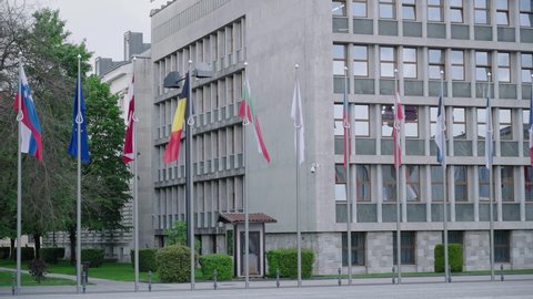 LJUBLJANA, SLOVENIA - 2021: Long shot panning over European flags in front of Slovenian Parliament 4K