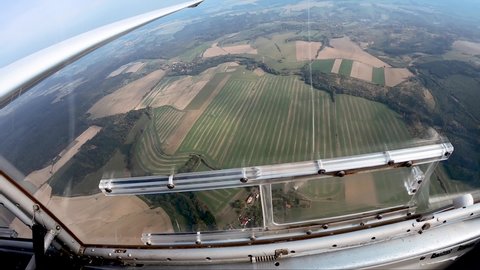 looking out of the window of a sailplane above fields and forests, pilot's point of view from a cockpit