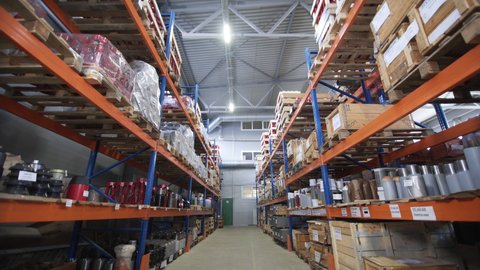 Warehouse with racks and shelves, filled with wooden boxes on pallets. Distribution products. Logistics Business. interior large warehouse with freight stacked high. Dolly shot