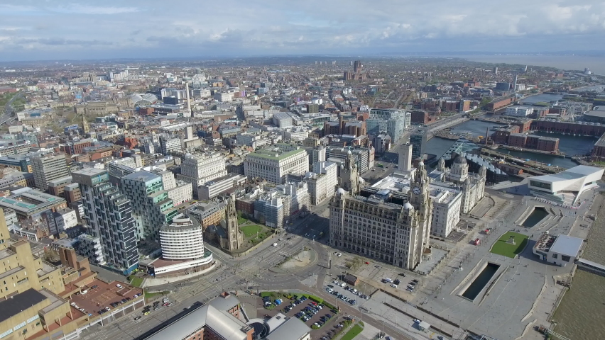 Aerial footage of Liverpool town center ft. cityscape skyline and central famous landmarks buildings such as Royal Liver Building, Museum of Liverpool, Tate, Albert Dock around River Mersey in UK