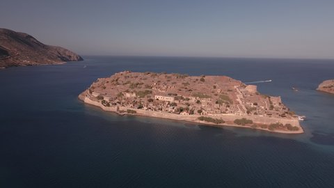 Spinalonga Greek island landscape drone shot with empty houses. Aerial top day view of famous deserted leper colony with fortifications, currently a tourist attraction, in north-eastern Crete. 