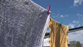 Colored towels moving in the wind on a clothesline on a sunny day with a blue sky