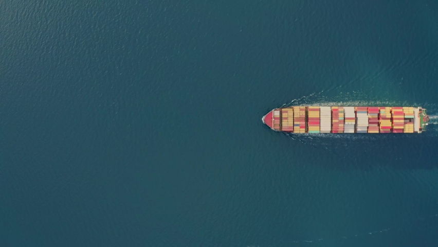 Aerial top view large cargo vessel ships under drone.Freight ship full of containers.Huge marine craft shipping import export cargo.Concept of sea transport logistics carriage.High quality 4k footage
