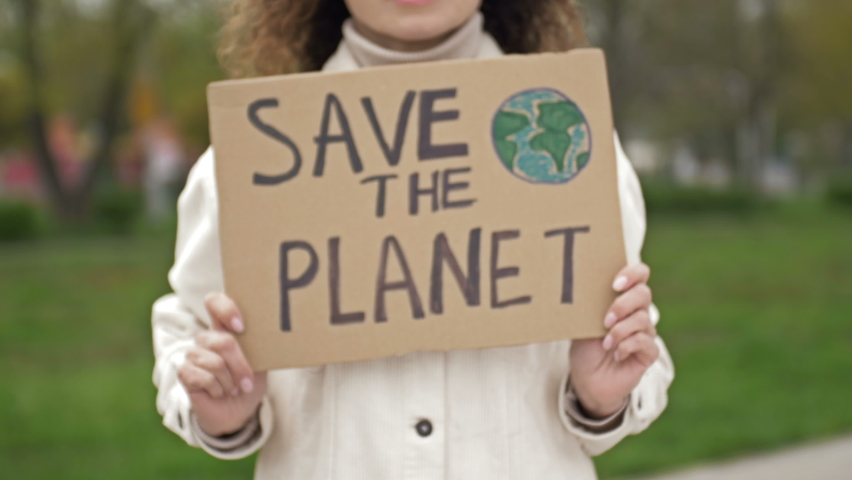 Woman with a poster SAVE THE PLANET. Feasible contribution to the fight against global pollution of nature. Single picket. | Shutterstock HD Video #1072872719