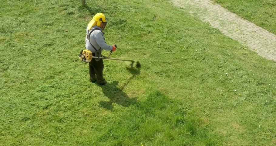 lawnmover man worker cutting dry grass with lawn mower. Royalty-Free Stock Footage #1072878602