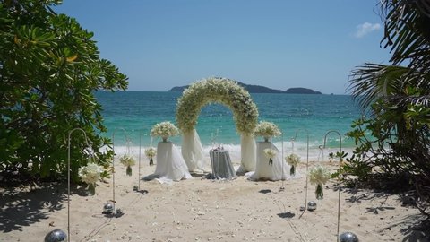 Beautiful Wedding event decoration beach sea tropical island sunset Germany. Set up arch decor flowers pattern coconut palm trees sand sunlight. Setting outdoor marriage detail table stage sky clouds.