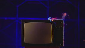 Old TV Set with big Screen in Fire . Old TVs burning on fire . Concept of modern technology , internet and anti-propaganda . Destruction of retro TV. 80s or 90s TV set blazing in slow motion
