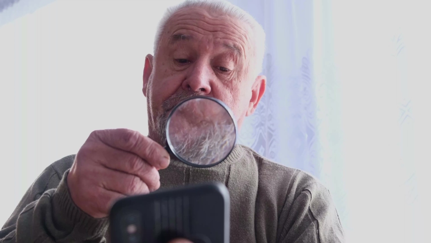 Old grandpa uses a smartphone. 