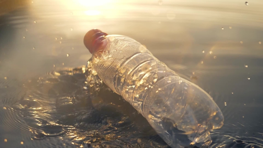 World's plastic pollution crisis. plastic trash in ocean. used bottle floating on water. plastic bottle pollution river, litter recycling concept. plastic waste in rivers and seas | Shutterstock HD Video #1072902917