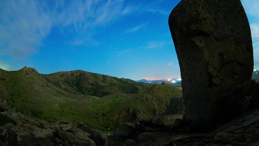 Night landscape with the Milky Way above old mountains of Dobrogea, Romania - motion lapse