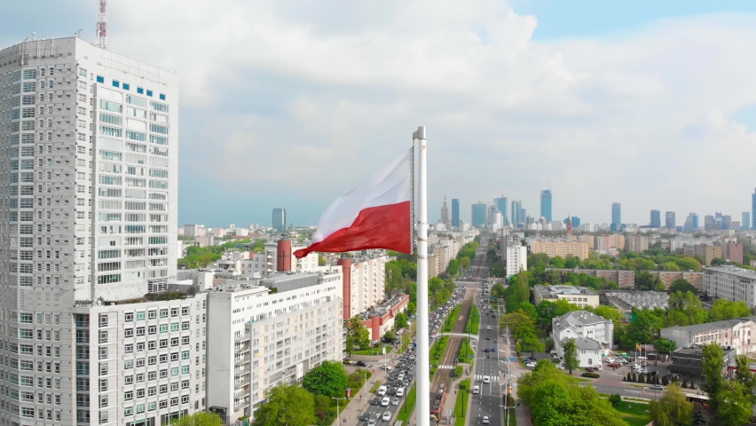 The white and red Polish flag waving in the wind. Warsaw city center in the background. Concept of national pride and celebration of the national day. Aerial view of the flag.
 Royalty-Free Stock Footage #1072909742