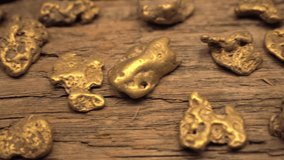 This panning video shows large pieces of gold nuggets laid out over wood.