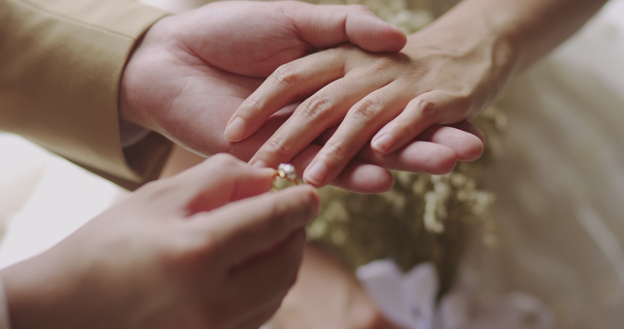 Close Up Hands Of Asian Groom Puts The Wedding Diamond Ring To The Bridal. Happiness Moment In Love Of Couple In The Wedding Day Ceremony. Royalty-Free Stock Footage #1072919063