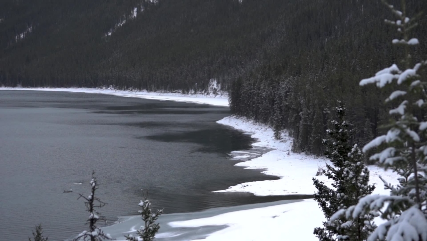 Slow pan of a snowed frozen lake in Banff National Park in Canada.
