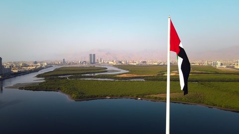 UAE national flag pole and Ras al Khaimah emirate in the northern United Arab Emirates aerial skyline landmark and skyline view above the mangroves and corniche downtown area