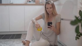 Woman at home using smartphone, eating an apple