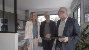 Real-estate agent with couple visiting modern house