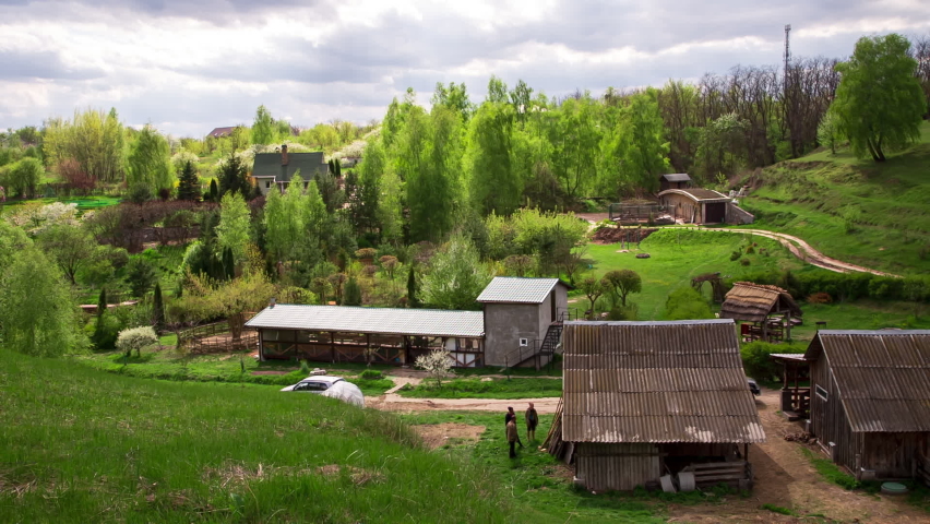 Beautiful rural landscape with green silky grass among green hills. Goat farm among silky green grass in the mountains