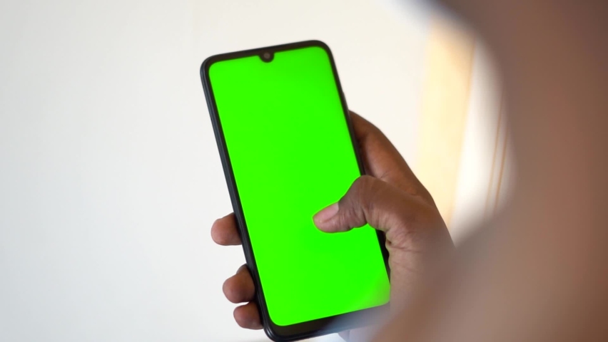 Closeup shot of hand using mobile phone with Green screen, Finger swiping up and down in green screen of the mobile. Green screen mockup template of Mobile phone, Chroma key Royalty-Free Stock Footage #1072940255