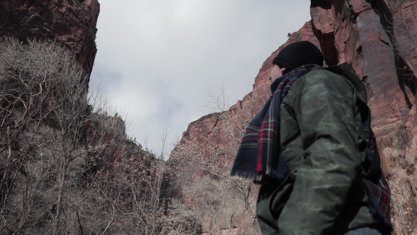 man looking to the sky between two mountains