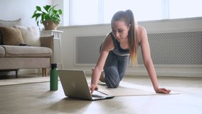 Woman exercise yoga plank in gym with online laptop tutorial Spbas. Young healthy sportive female
