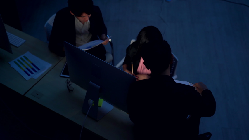 Asian businessman and businesswoman office worker working overtime together in modern office at night. Business people colleague teamwork meeting and brainstorm ideas for success business project | Shutterstock HD Video #1072947875