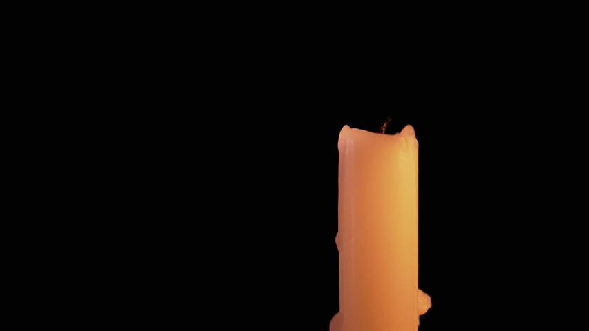 Female Hand Lights Paraffin Candle using a Match on a Black Background. Bright flame, fire, ignition in a dark room. White candle with yellow fire. Concept of memory, ritual, celebration. Slow motion. Royalty-Free Stock Footage #1072949120