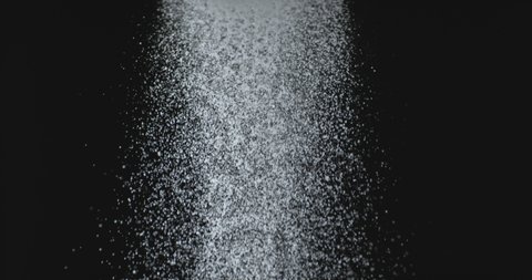 White powder falling against black ground in super slow motion