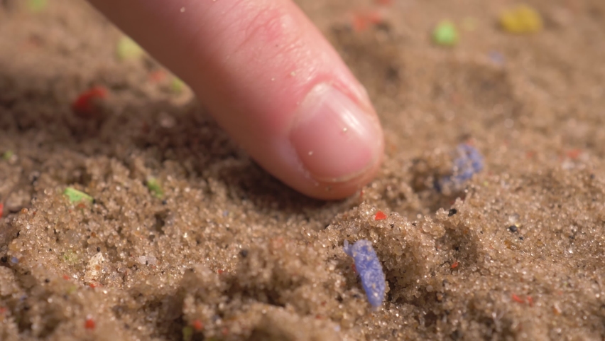 microplastics on sandy beaches, tiny multicolored plastic bits in sand. microplastic pollution. plastic pollution that affects wildlife, wildlife habitat, and humans