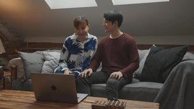 Young asian couple talking on the video call over the laptop at home.