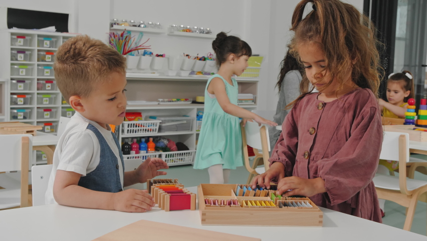 Boy and girl playing with develoment toys together in the kindergarden. Royalty-Free Stock Footage #1072966400