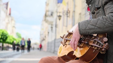 musician playing the lyre on a crowded street. Close-up shooting of a lyre game.