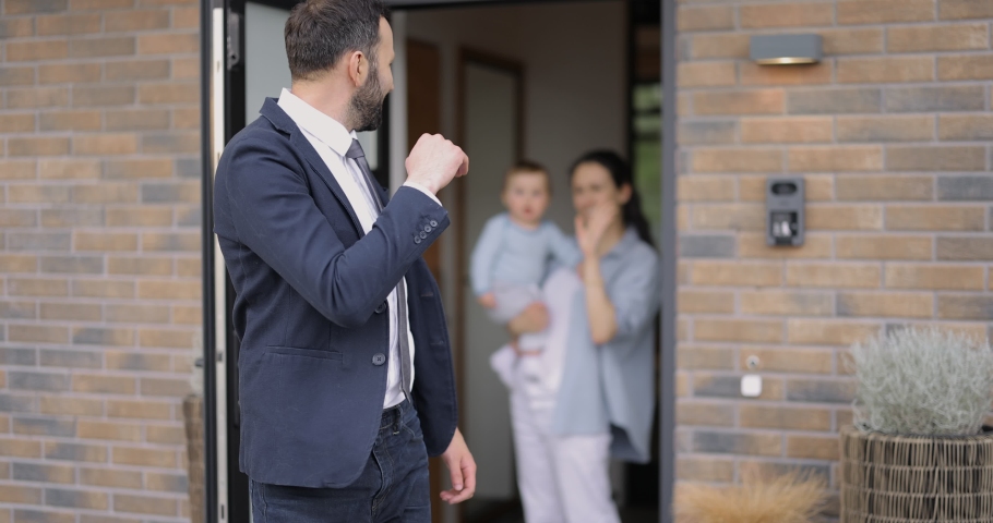 Businessman going out at work, kissing and saying goodbye to his wife and baby at the door way of the house Royalty-Free Stock Footage #1072970177