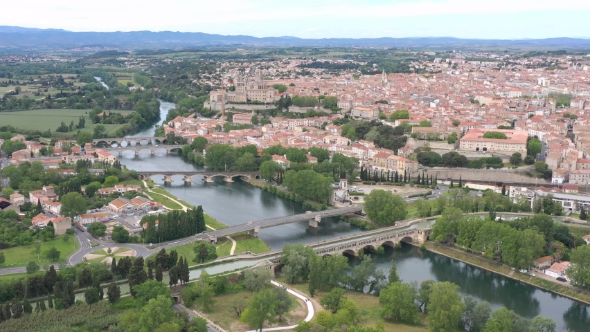 France, Beziers, bridges over Orb river and Saint-Nazaire cathedral in back, wide drone aerial view
