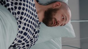 Vertical video: Patient sitting in bed while woman doctor putting oxygen mask monitoring respiratory illness. Physician medic writing sickness treatment working in hospital ward during recovery
