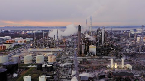 Stanlow oil refinery cheshire. Long sliding drone shot of large oil refining site in the UK at sunset in winter. Drone flown across farmland opposite site. 4K 25fps 10bit DLOG-REC709