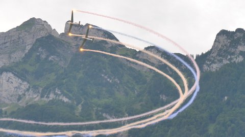 Zigermeet Airshow in Mollis Switzerland August 16th 2019. The colored smoke trails of two vintage gliders in flight create a beautiful looping. Let L-13 Blanik of the Red Bull Blanix Team