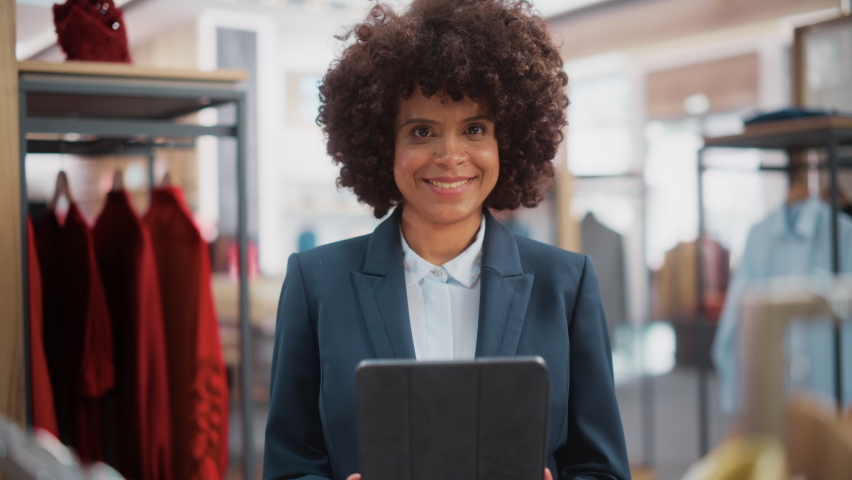 Portrait of a Happy Female Merchandising Manager Using Tablet Computer at a Stylish Clothing Store. Professional Shop Sales Retail Assistant Checks Stock. Small Business Owner Orders Mall Items. | Shutterstock HD Video #1073014877