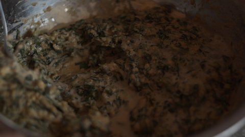 Chef stirring with a spoon flour, herbs and wild garlic in a bowl. Knead the dough for vegetable cutlets. Vegetarian proper nutrition. Healthy lifestyle. Culinary. Cooking vegan food Close-up 4K