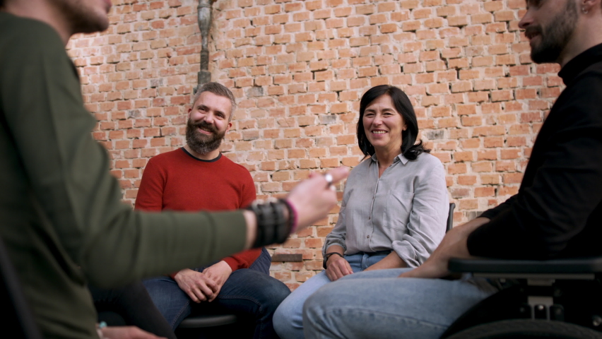 Group of people on therapy session having fun, mature man looking at camera.
