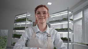 online business, successful female seller communicates via video call on laptop and sells micro green in a package sitting backdrop of shelves in store