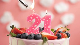 Birthday cake candle number 21. Candle and cake on pink background and fire by lighter. Close-up and slow motion - Powered by Shutterstock - Get 15% off with code: PIKWIZARD15