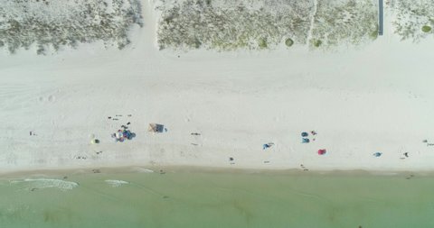 Top Down Aerial view of people at the White Sand Beach and in the Ocean