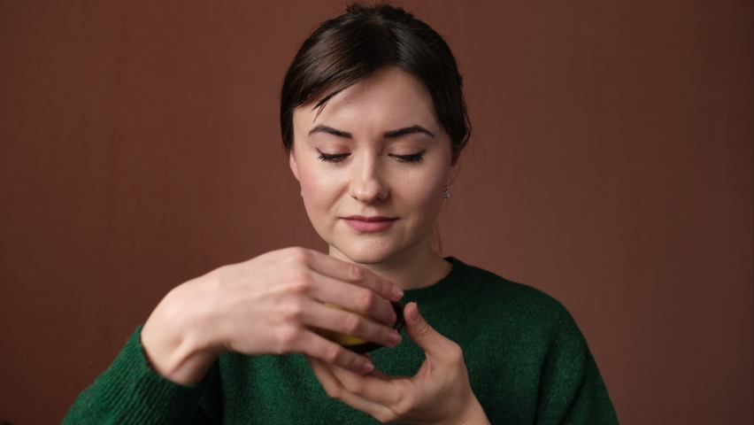 Slow motion: The happy girl is eating a sweet little cake and enjoying it. Concept of dessert. Closeup portrait