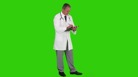 Chroma-key footage of a mature doctor writing something on his book, Healthcare workers in the Coronavirus Covid19 pandemic