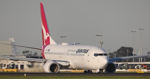 Melbourne, Australia - May 22, 2021: Qantas Boeing 737 commercial airliner aircraft taxiing for departure while another Qantas aircraft lads on the runway in front of it.