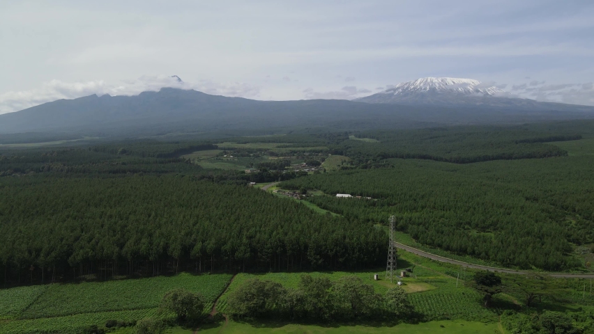 Evergreen Landscape With Countryside Road At Snowcapped Peak Of Mount Kilimanjaro In Kenya, Africa. - Aerial Drone Shot