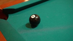 Slow Motion Billiards solid black 8 ball shot in corner pocket on pool table with green felt and brown pockets using the cue ball and back spin or draw Close Up with Red Spinning Dots - Powered by Shutterstock - Get 15% off with code: PIKWIZARD15