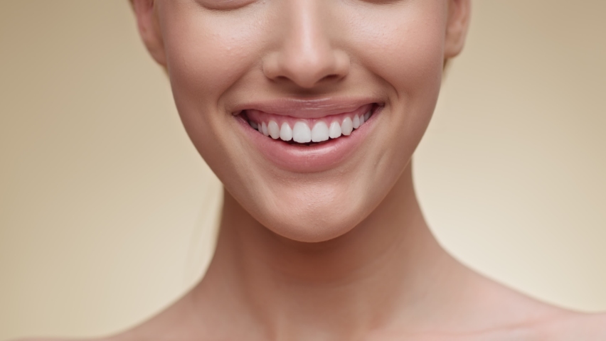 Dental care and stomatology concept. Closeup of happy caucasian woman smiling to camera, showing white smile of after teeth alignment procedure, beige studio background, slow motion | Shutterstock HD Video #1073065220